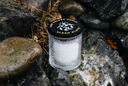Single Wick Clean Slate Candle amongst rocks and stone.