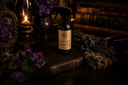 Bottle of 'Velvet Sparkle' on a wooden surface with purple flowers and a candle.