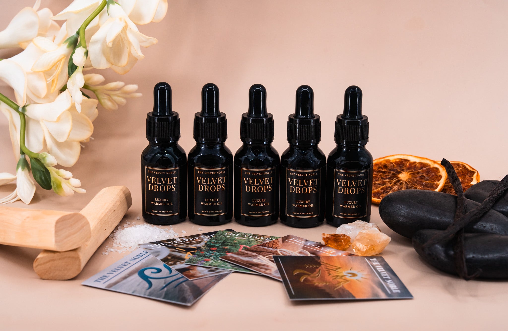 Set of 'Velvet Drops' dropper bottles on a table with decorative items.