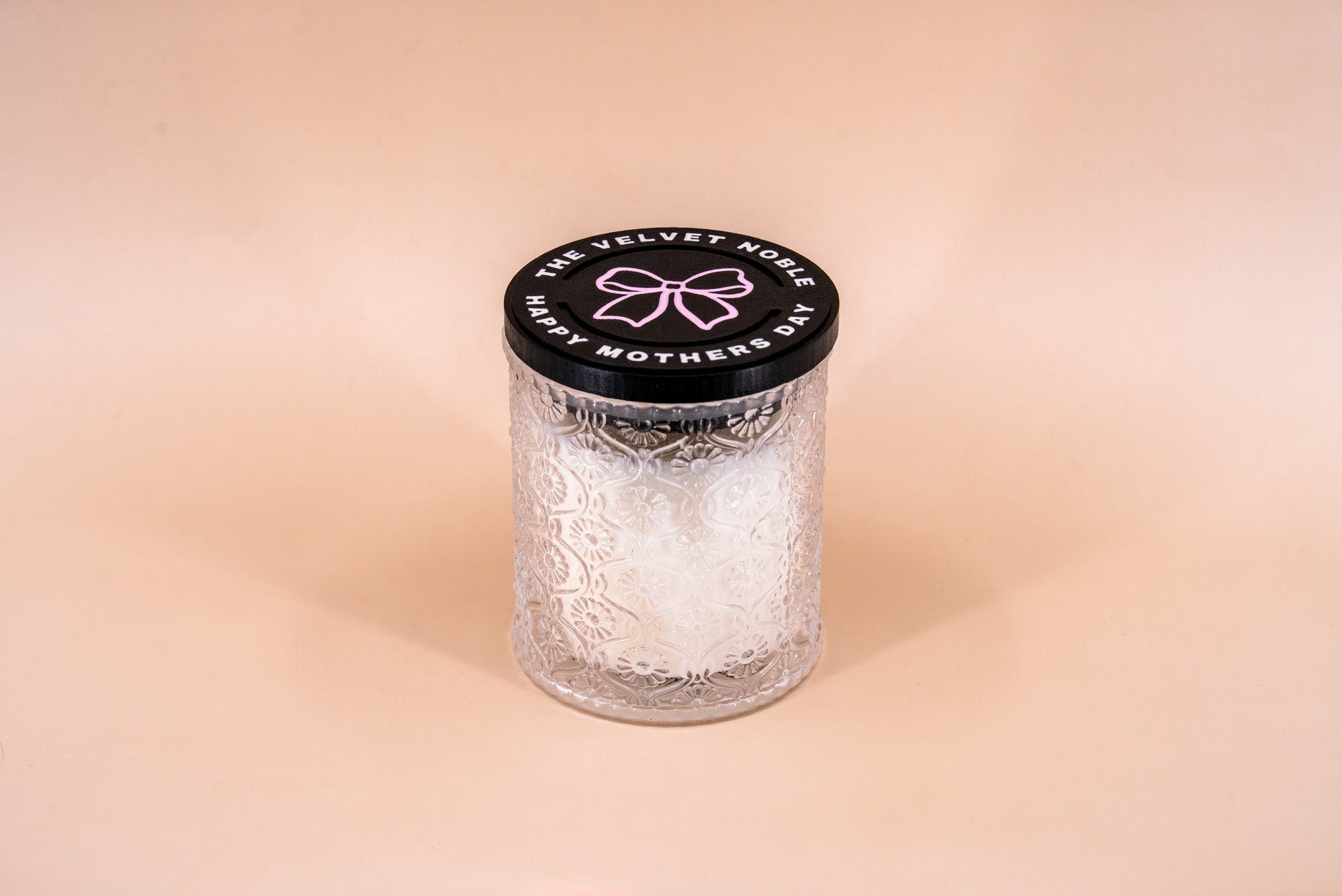 Candle with decorative Mother's Day lid on a beige background