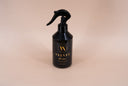 Black spray bottle labeled 'Velvet Home' on a beige background