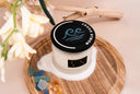 Noble Coast 2-wick candle on a wooden tray with driftwood, sea glass, amber and sand. 