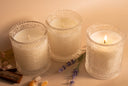 Three candles with lavender flowers on a beige background
