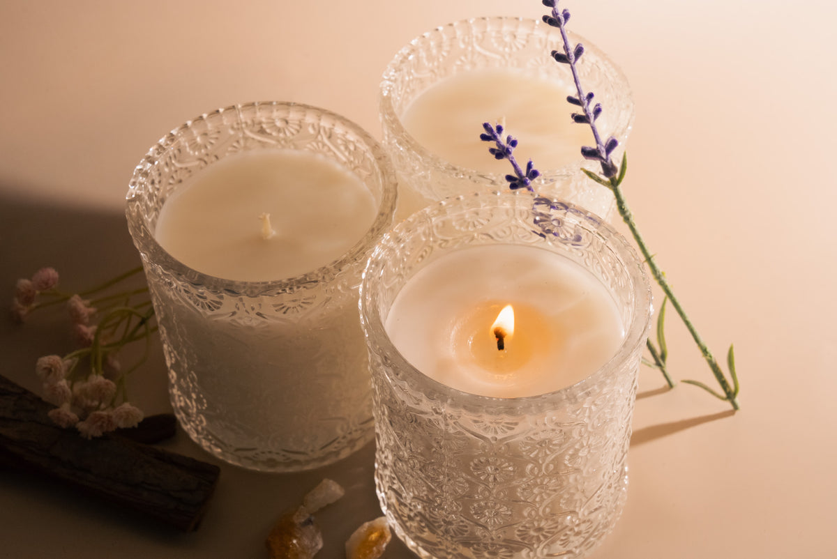 Three candles with lavender flowers on a beige background