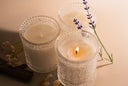 Three candles with lavender flowers on a beige background