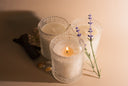 Three candles with lavender flowers on a beige background