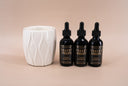 Three bottles of Velvet Drops with a white fragrance warmer on a beige background