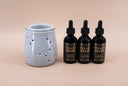Three bottles of Velvet Drops with a blue fragrance warmer on a beige background
