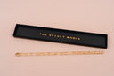 A clear and gold specked luster wand with a black and gold holding tray with "THE VELVE NOBLE" inset into it.