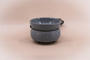A gray textured ceramic fragrance warmer photographed on a plain beige background.