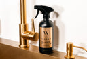 Spray bottle labeled 'Velvet Sparkle' on a kitchen counter with gold fixtures.