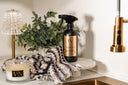 Bottle of 'Velvet Sparkle' cleaner on a kitchen counter with a plant and candle.