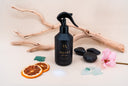 Black spray bottle labeled 'Velvet Home' on a neutral background with decorative elements.
