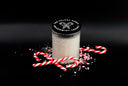 A clear glass jar filled with white peppermint lemon salt, sealed with a black lid printed with 'THE VELVET NOBLE PEPPERMINT LEGACY', styled with candy canes and crushed peppermint on a black background.