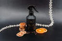 Black spray bottle with decorative elements on a dark background