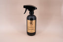 Black spray bottle labeled 'Velvet Sparkle' on a beige background