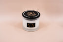 Vanilla candle with a black lid on a beige background