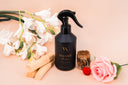 Black spray bottle labeled 'Velvet Home' with flowers and candles on a beige background