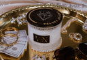 Velvet Stacks 2-Wick Candle on a gold tray with Jewelry, Cash, and Sunglasses