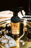 Bottle of 'Velvet Sparkle' cleaner on a reflective surface with jewelry and money.