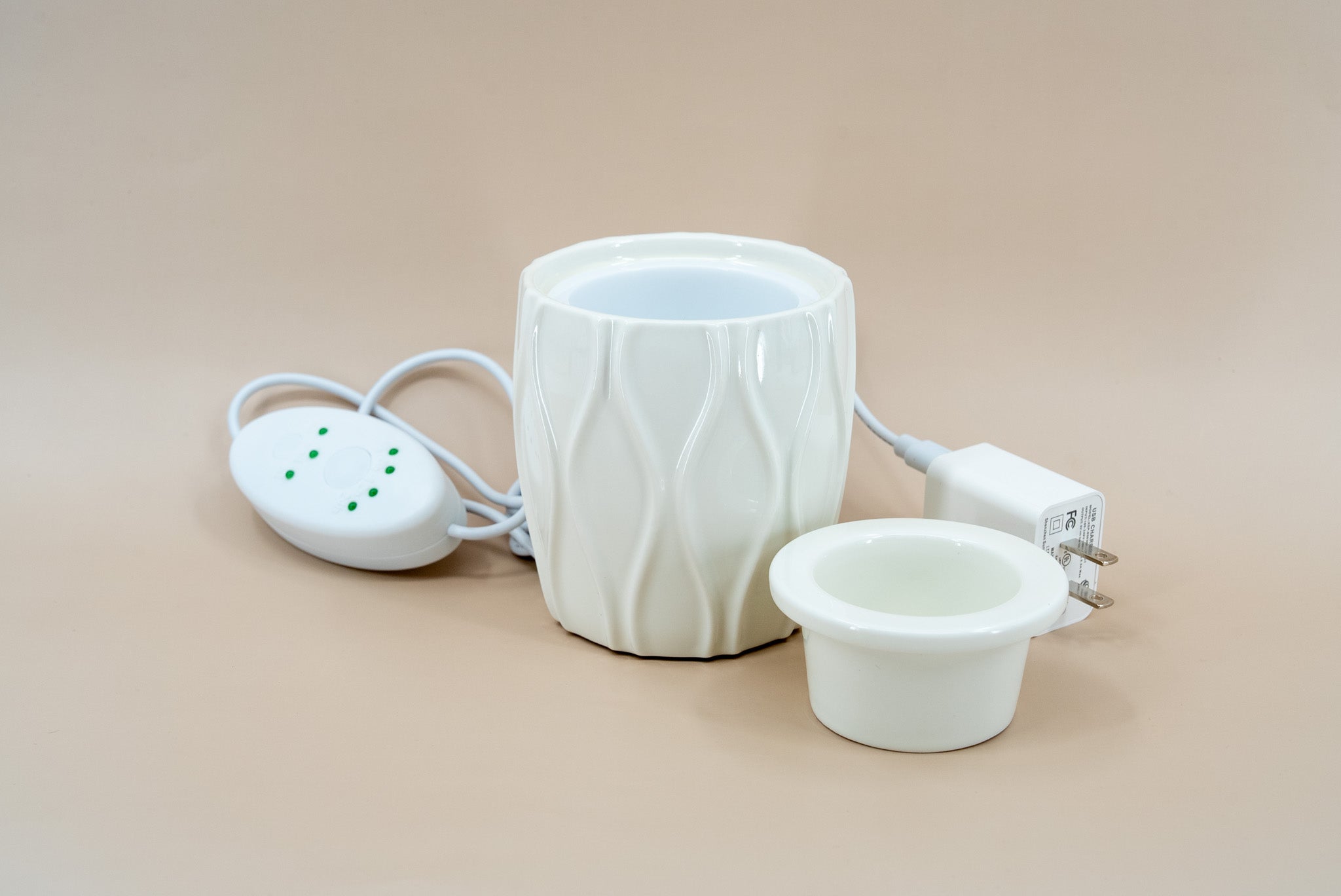 A ceramic fragrance warmer on a beige background.