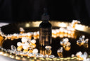 Bottle of 'Velvet Drops' with decorative elements on a reflective surface