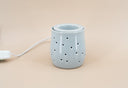 Light blue fragrance warmer on a beige background