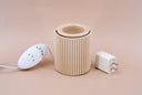Beige ribbed light brown fragrance warmer with white plug and controller on a beige background