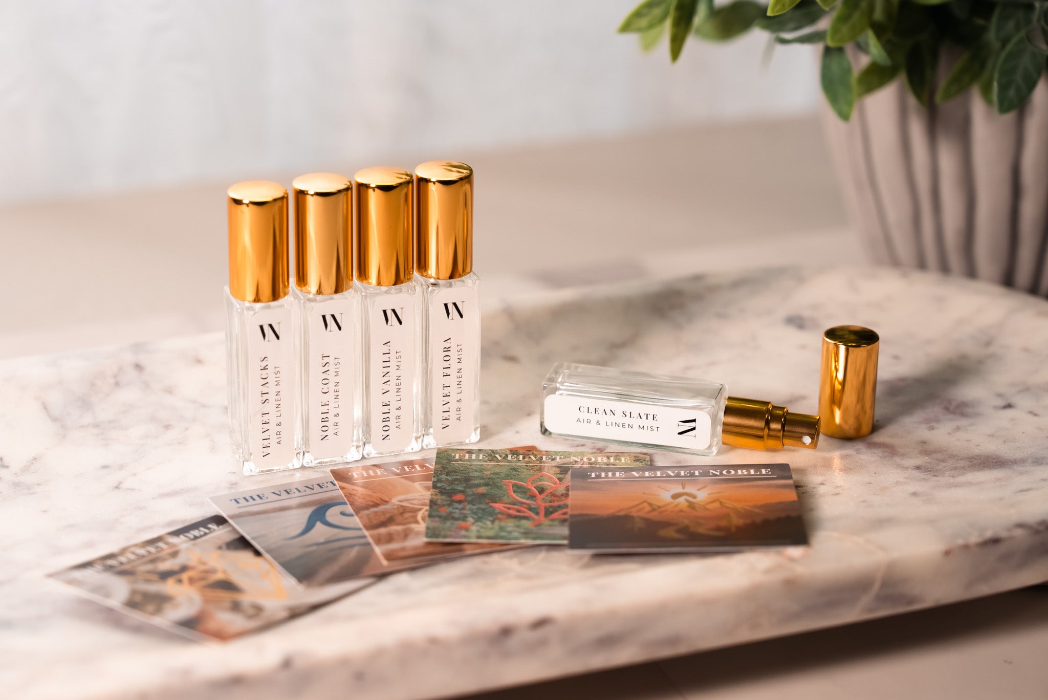 5 Small Air & Linen Mist bottles with golden caps. Velvet Stacks, Noble Coast, Noble Vanilla, Velvet Flora, & Clean Slate.