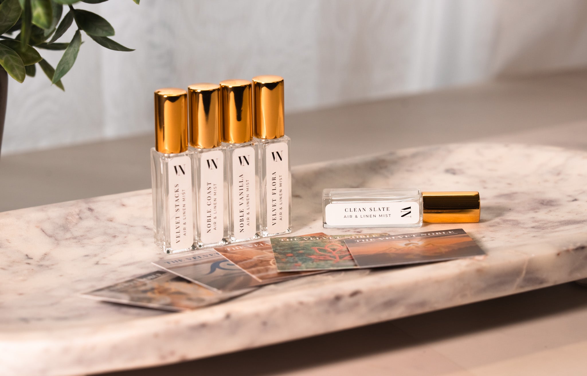 5 Small Air & Linen Mist bottles with golden caps. Velvet Stacks, Noble Coast, Noble Vanilla, Velvet Flora, & Clean Slate.