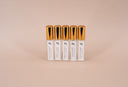 5 Small Air & Linen Mist bottles with golden caps. Velvet Stacks, Noble Coast, Noble Vanilla, Velvet Flora, & Clean Slate on a beige background.