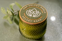 Velvet Ease candle with 'The Velvet Noble' logo on a reflective surface