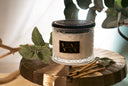 Velvet Ease Candle with Mint and matches on a golden surface.
