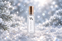 A clear glass bottle of Diamond Frost Air & Linen Mist with a metallic gold cap, set against a festive, snowy background with pine branches and sparkling lights.
