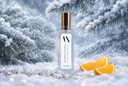 A clear rectangular bottle labeled VN Diamond Frost with a metallic gold cap, standing in snowy winter branches with orange slices nearby.