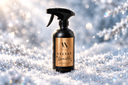 A black trigger spray bottle with a gold label reading 'VELVET Sparkle' and a circular 'VN' logo, standing in snowy glitter against a bright, sparkling winter background.
