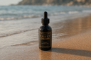 Bottle of 'Velvet Drops' on a beach with ocean in the background