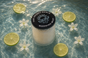 Morning Mist Candle in a pool of fresh, clear water with Citrus and flowers.