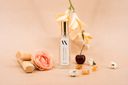 A mini Velvet Flora Air & Linen mist on a beige background with Amber, flowers, sandalwood and a cherry.