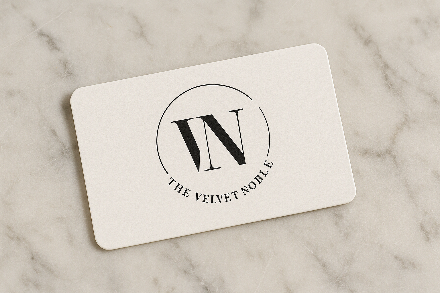 White card with 'The Velvet Noble' logo on a marble surface
