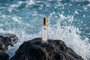 Noble Coast Mini Air & Linen Mist on a rock with ocean waves in the background
