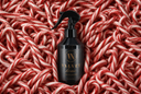 A black spray bottle labeled 'VELVET home' with gold lettering sits centered on a dense bed of red-and-white candy canes. The bottle has a black trigger sprayer and a circular 'VN' logo on the front.