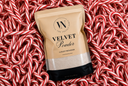 A stand-up pouch of Velvet Powder luxury freshener placed on a bed of red and white candy canes. The pouch is beige with black text and a black base, and the brand logo reads 'VN The Velvet Noble'.