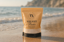 Package of Velvet Powder on a beach with ocean waves in the background