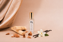 Mini Air & Linen mist with vanilla beans, flowers, and a wooden stick on a beige background