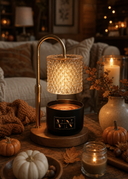 A warm autumn-themed candle lamp with a black jar, glowing amber wax, and a textured clear glass shade on a wooden base, styled on a rustic table with pumpkins, candles, and cozy home decor in the background.